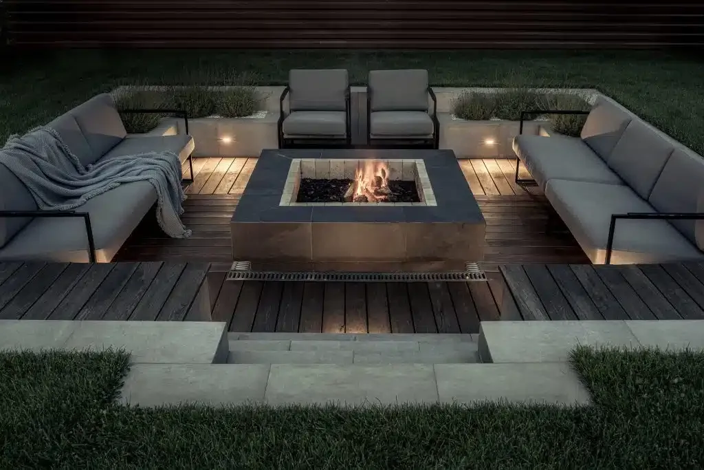 Built-in stone fire pit lounge with steps and lighting